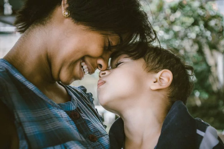 mother and son smiling and hugging each other