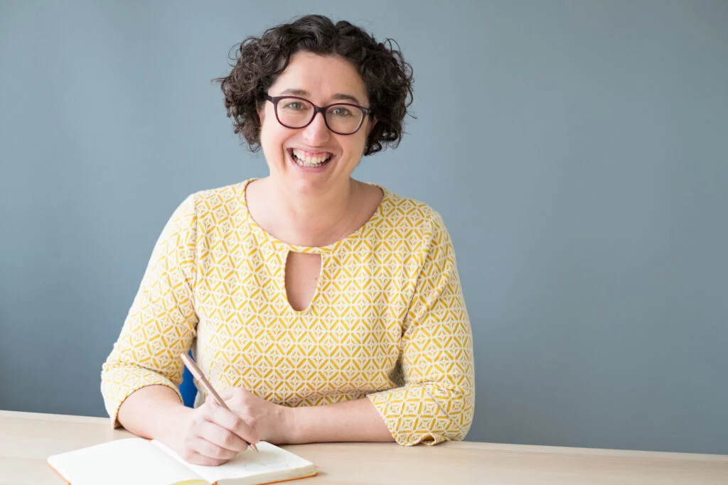 Woman Life Coach sitting at a desk journaling