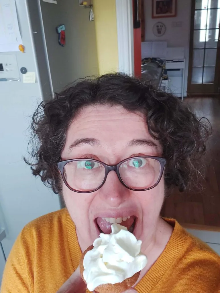 woman with ADHD doing silly face while eating cupcake