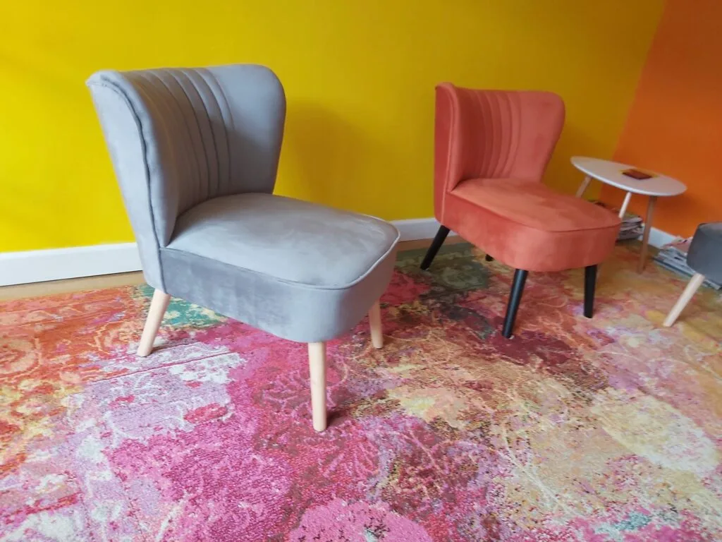 colourful chairs placed on a colourful rug in a circle