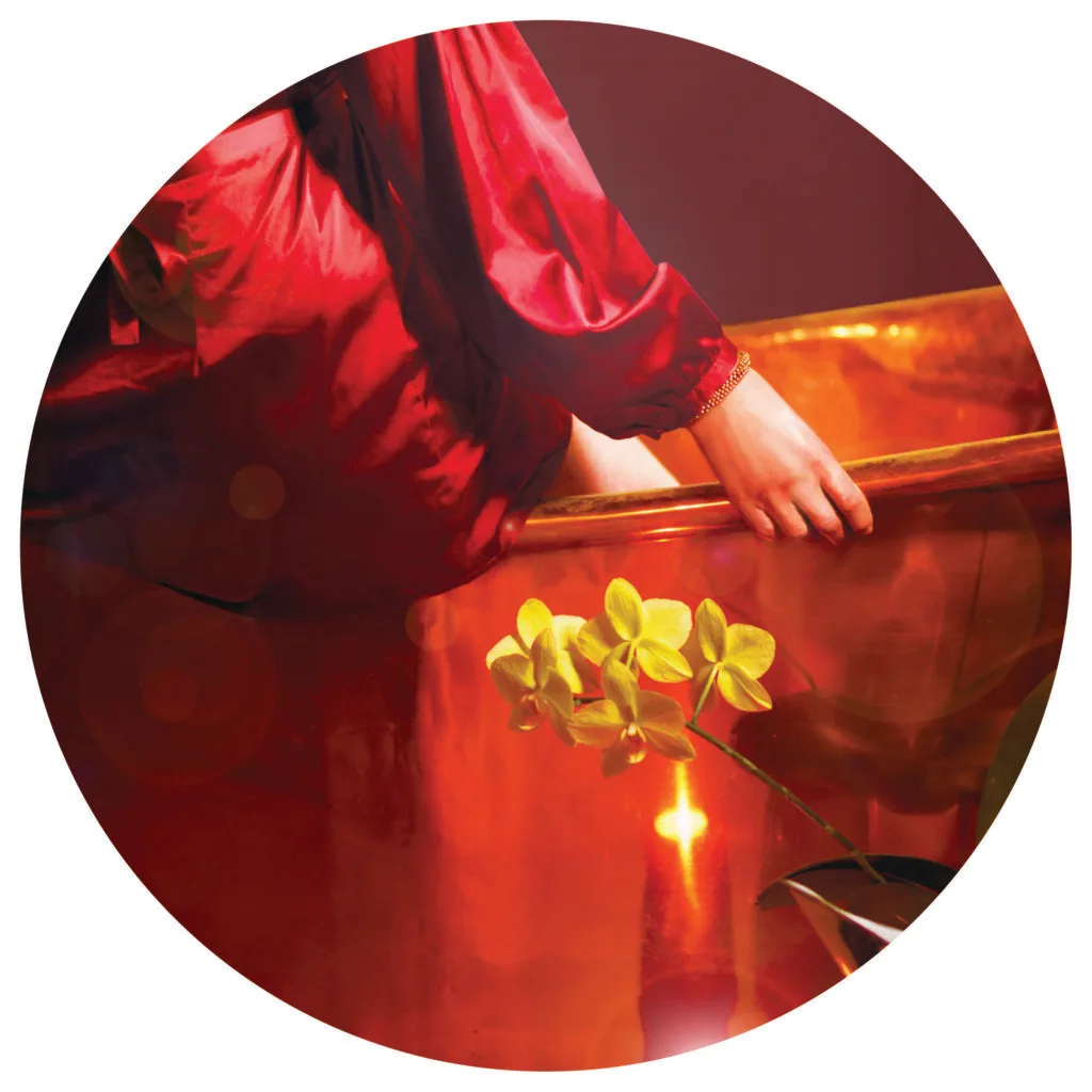 Lover Powertype showing the back of a woman in a red luxurious robe sitting on a copper bath