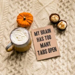 white ceramic mug with coffee and a sign saying My brain has too many tabs open ADHD