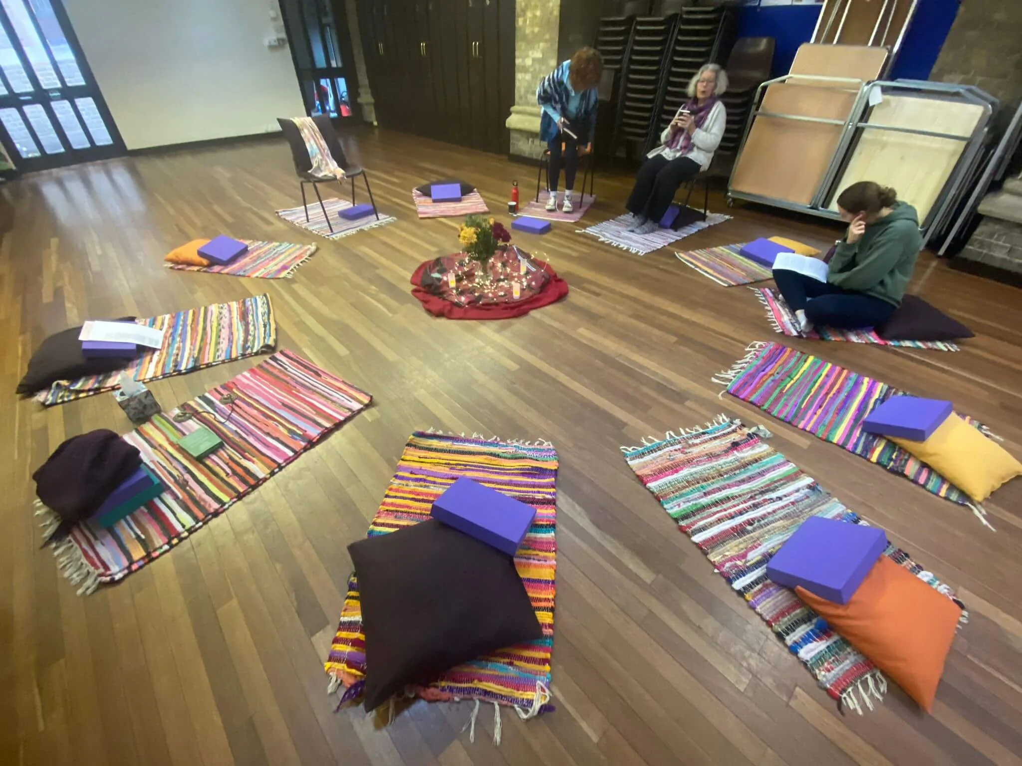 women circle with colourful mats arranged in a circle