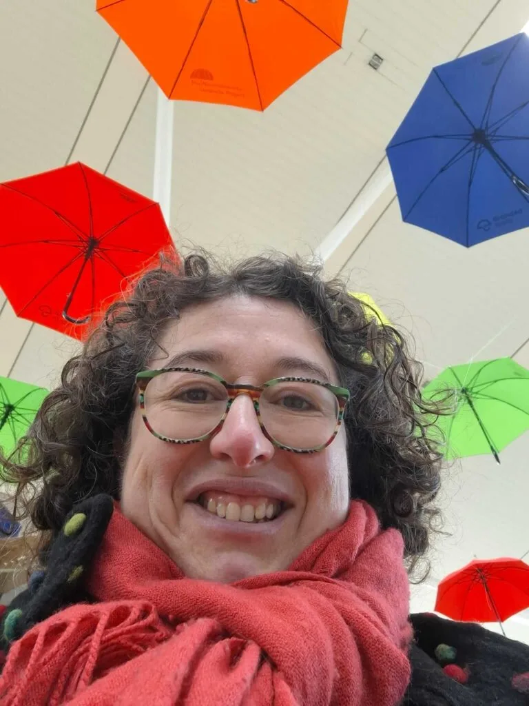Peggy Cheyo taking a selfie uneder colourful umbrellas from the umbrella project ADHD milton keynes